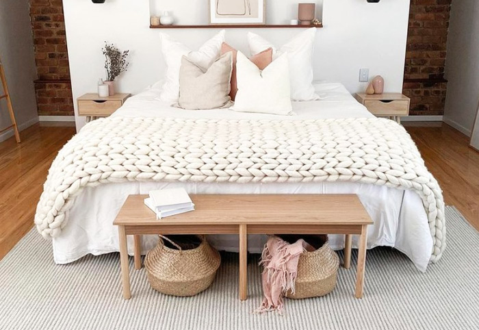 Neutral pale grey bedroom rug underneath a wooden bench seat.
