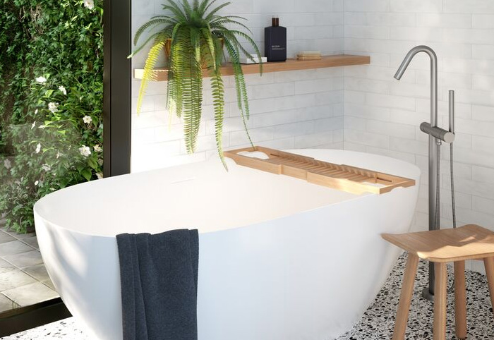 Bath tub next to a window shown with a plant and bath tray.