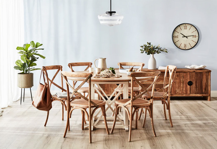 Country-style family table with six chairs around it in a light-filled space.
