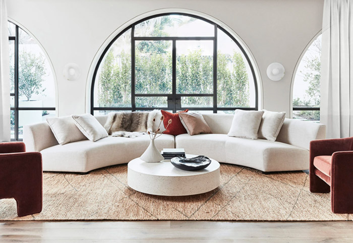 White curved lounge suite in front of a round window.