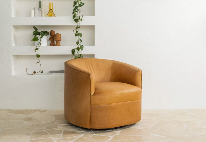 Tan leather accent chair against a white wall