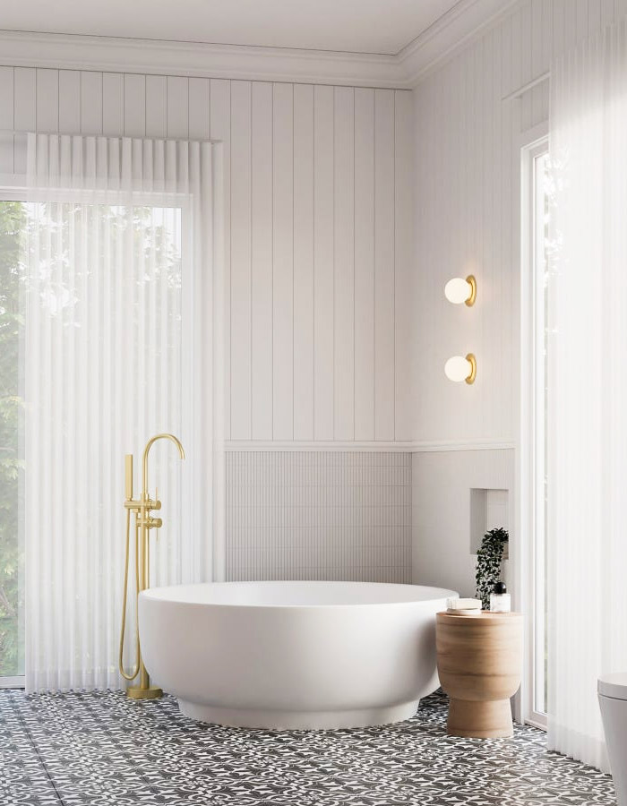 Circular bathtub with gold tapware in a modern bathroom.