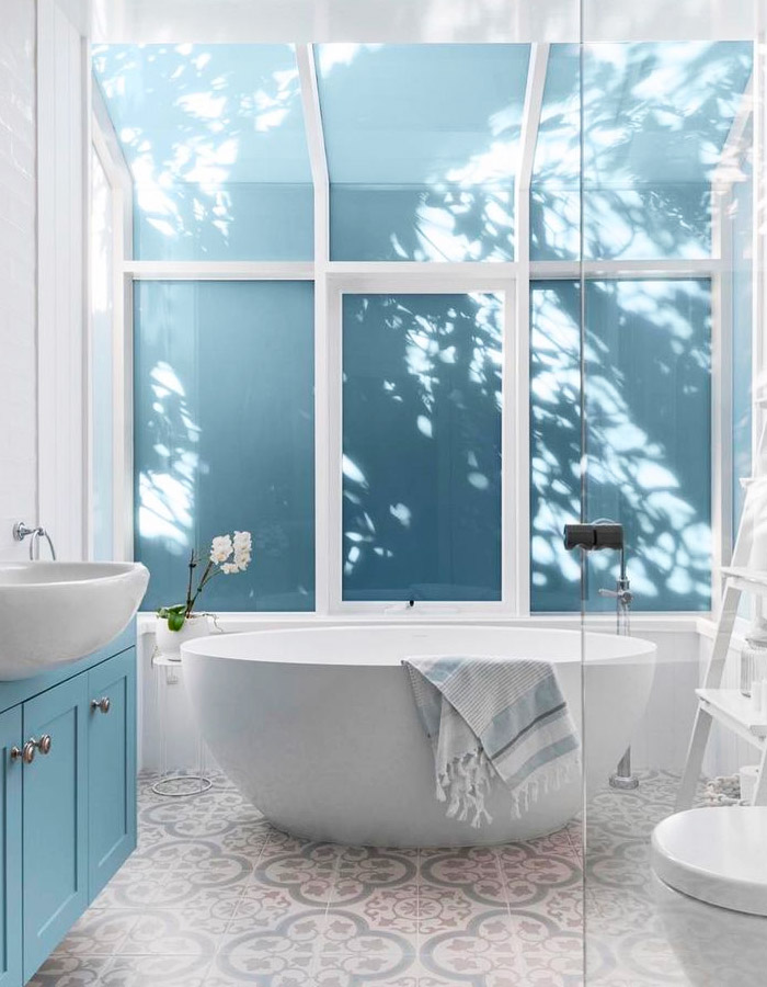 Mediterranean-style bathroom with round bathtub and blue Spanish tiles.