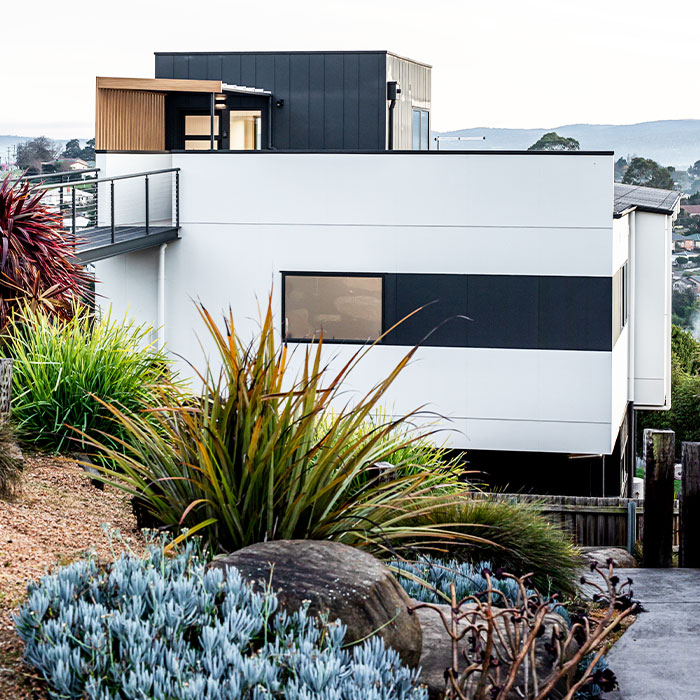 Modern house on a slope surrounded by Australian plants