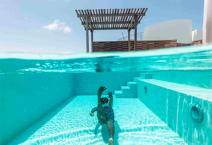 Person swimming underwater in a clean magnesium pool.