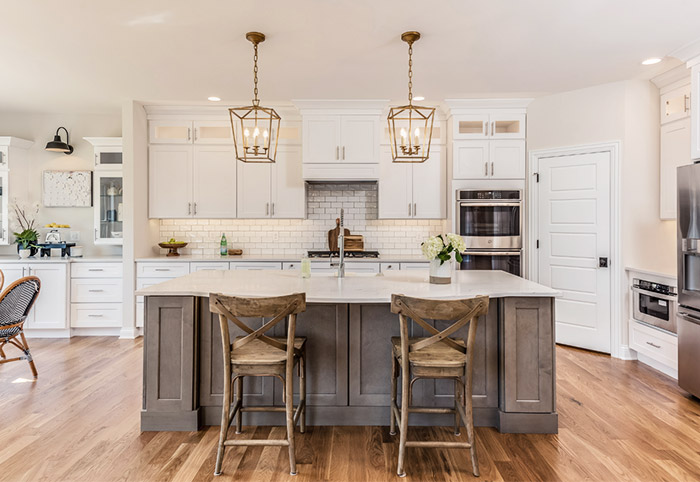 Hamptons-style kitchen with brass pendant lights over the bench.