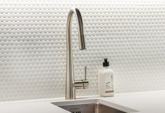 Brushed nickel pull-down tap with a built-in sink.