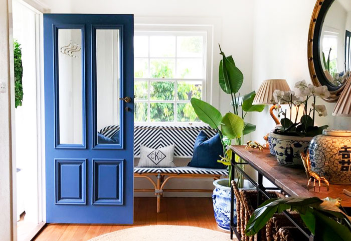 Internal entrance of a home with an open blue front door.