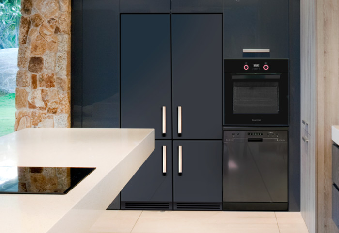 Black dishwasher built into blue cabinetry in a modern kitchen.