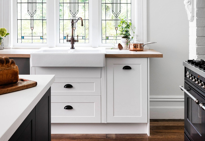White farmhouse kitchen cabinets with black cup handles.
