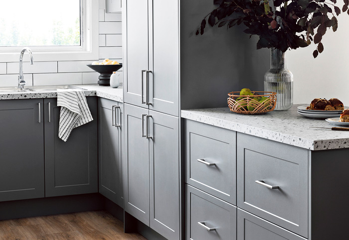 Modern kitchen with grey shaker cabinets with silver pull handles.