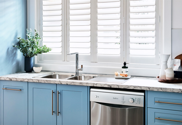 Blue coastal kitchen cupboards with long silver t-pull handles.