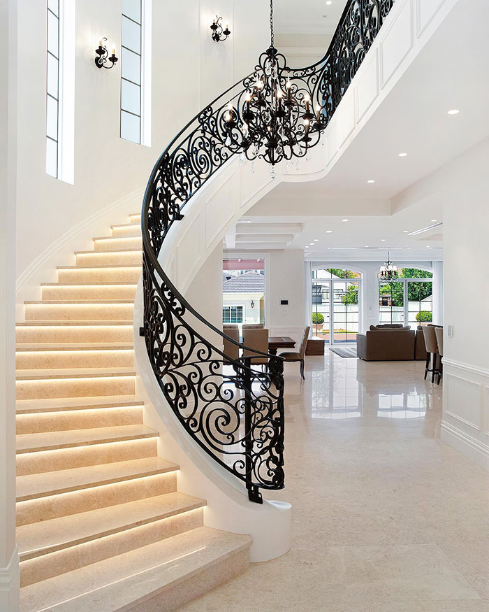 Beautiful curved staircase with wrought iron balustrade.
