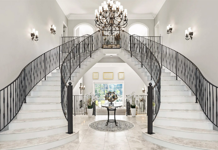 A grand double staircase in a French Provincial modern home.