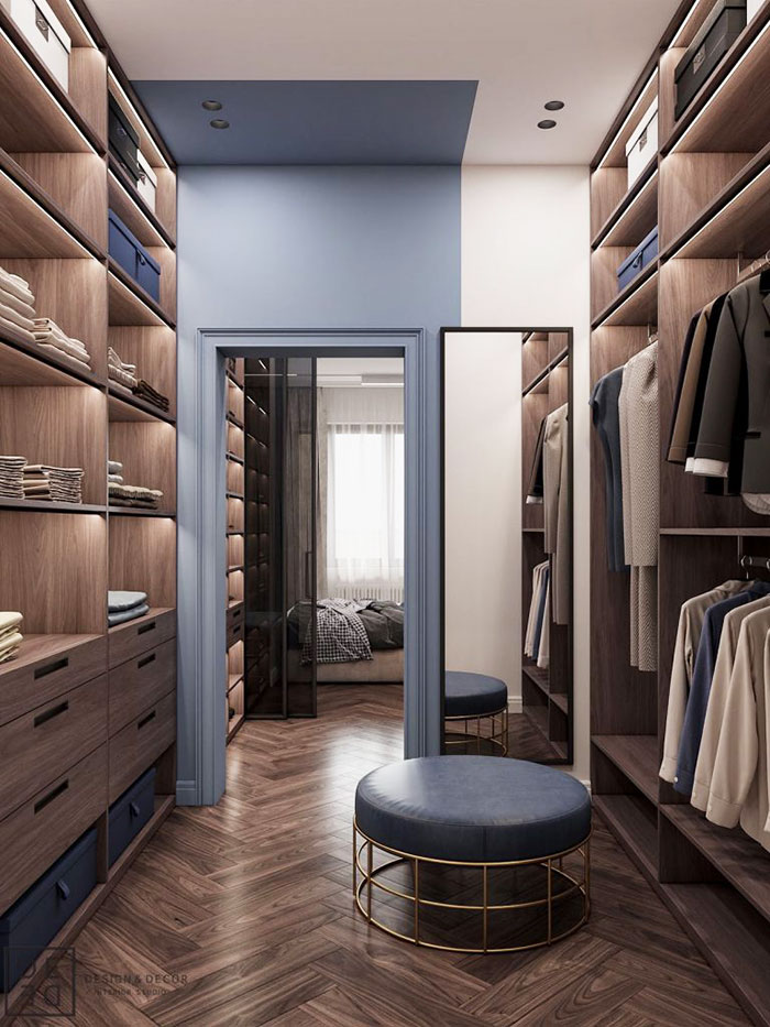 A classic walk-in wardrobe with herringbone wooden floor and wooden shelving.