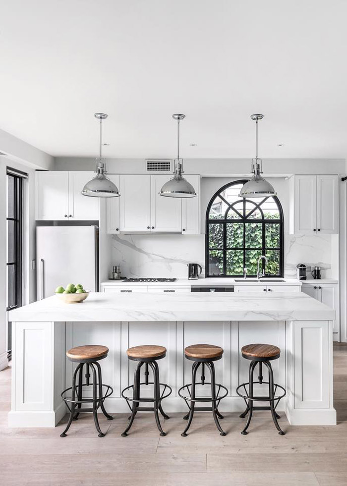 White and black kitchen with a large arched black feature window.
