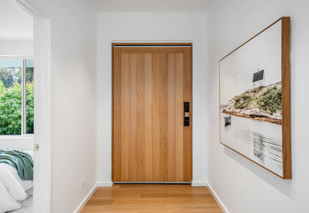 Timber front door shown from the foyer of a contemporary house.