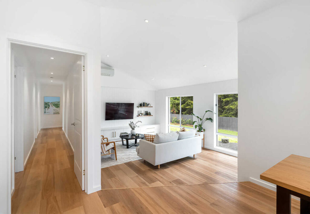Split-level living room with timber floors and white walls.
