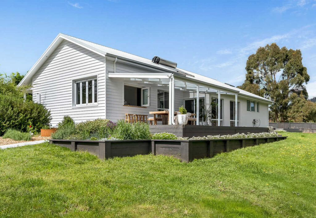 Weatherboard country home in a green landscape.