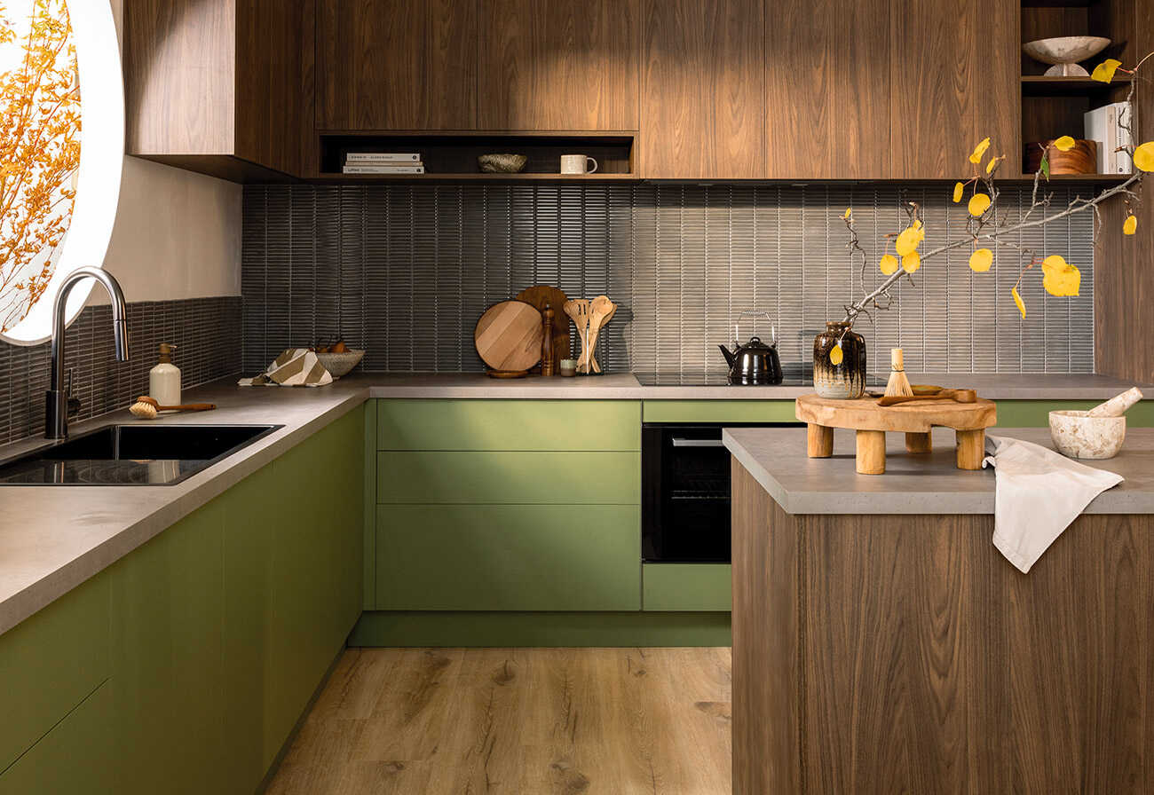 Japandi style kitchen with a combination of green and walnut cabinetry.