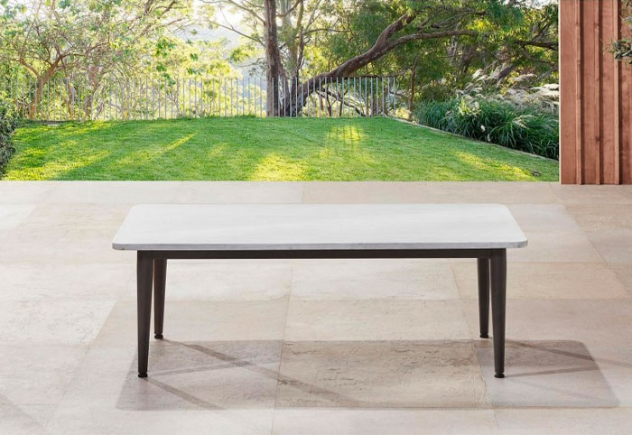 Portia concrete coffee table on outdoor paved patio.