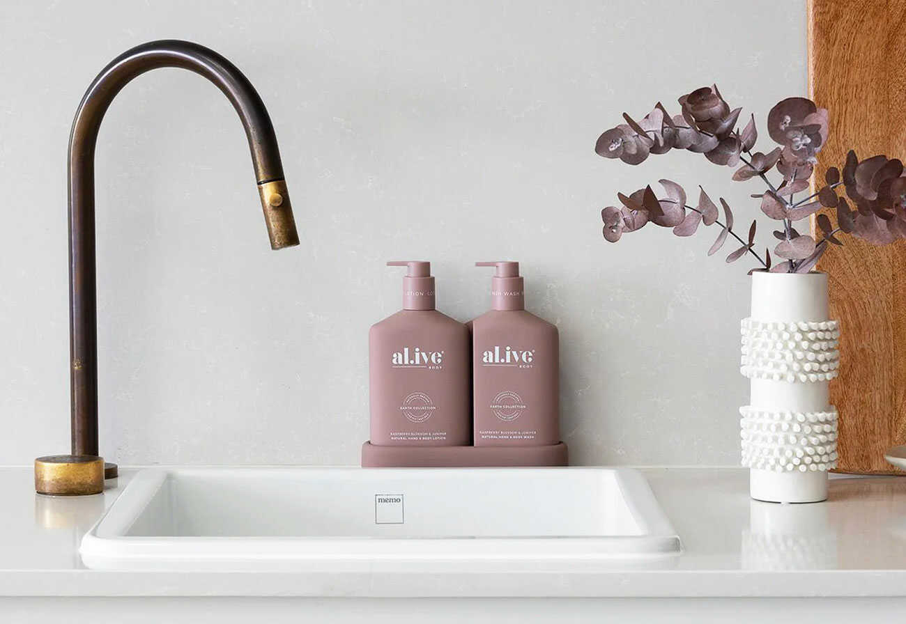 Boutique handwash sits behind a white sink with a copper tap.
