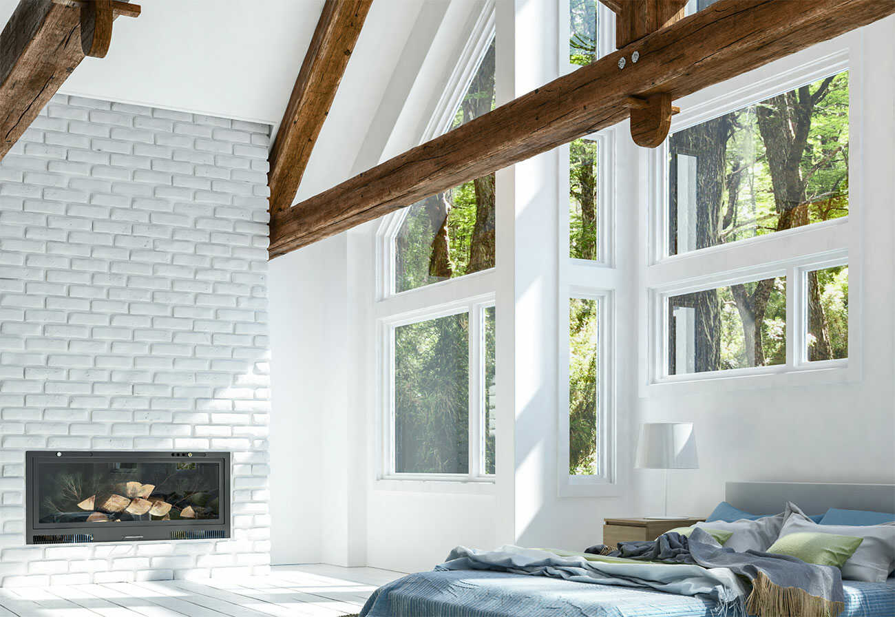 White exposed brick wall in a bedroom with timber beams.