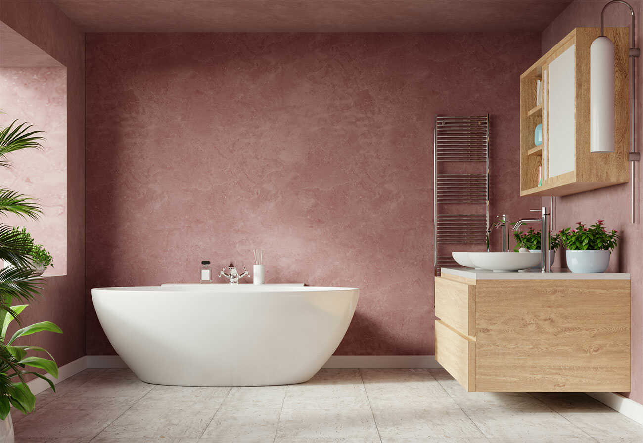 White egg-shaped bathtub against a pink feature wall.