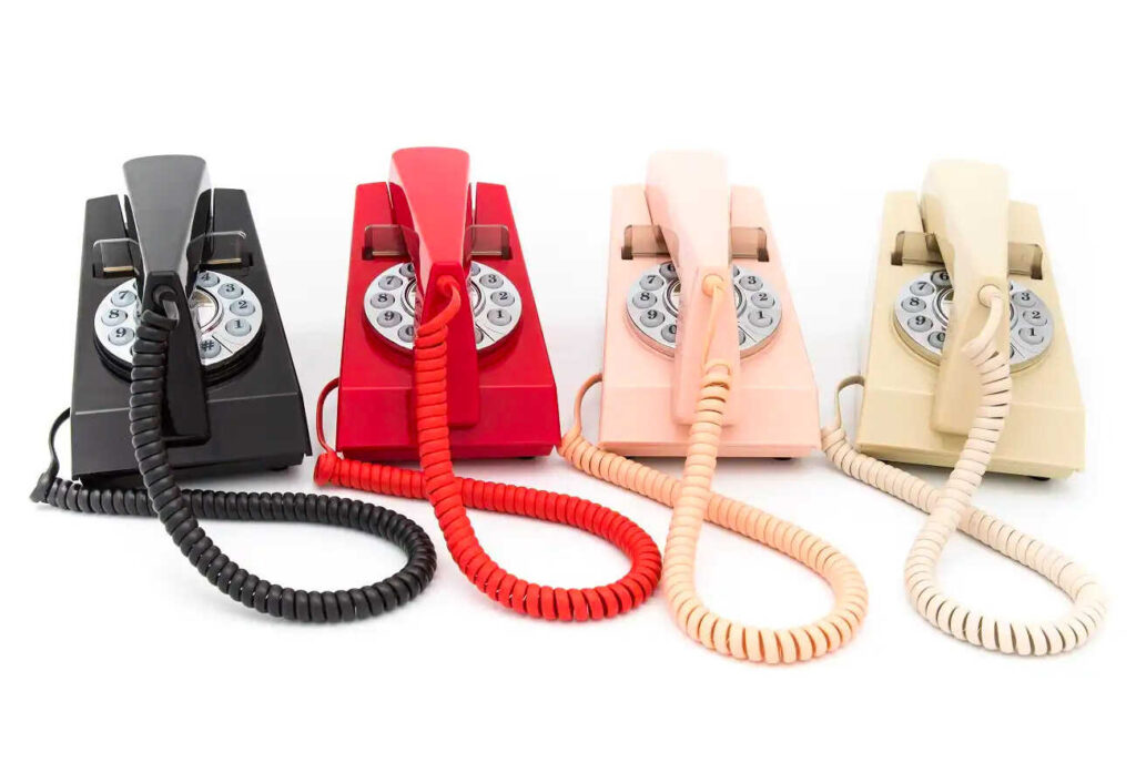 Row of four vintage push-button phones.