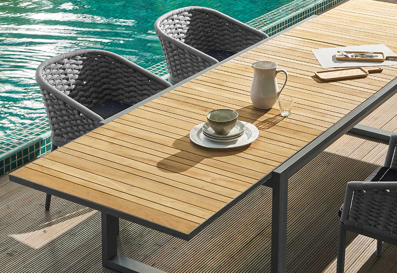 Timber extension table next to a swimming pool.