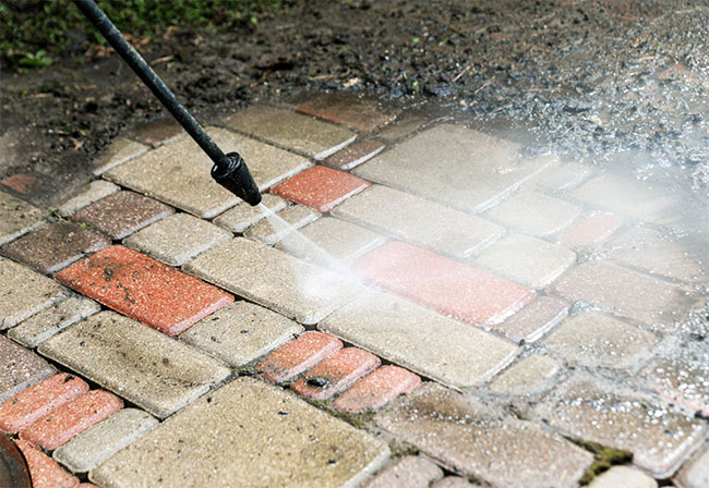 Pressure washing brick paving.