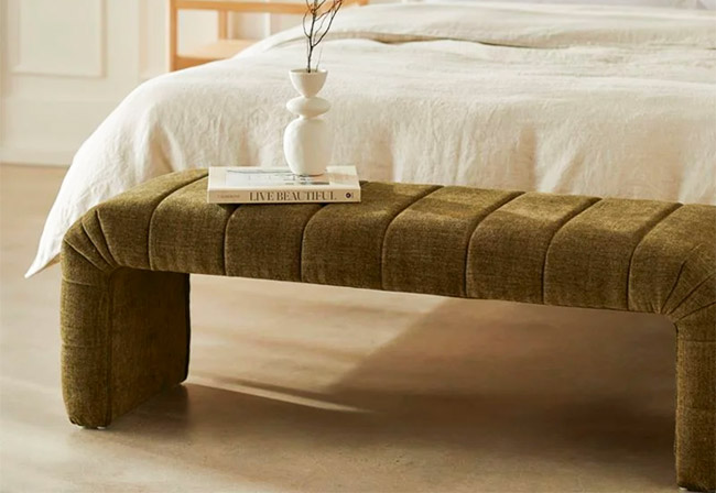 Adairs Carson Olive Bench Seat positioned at the end of a white bed.