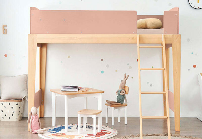 Pink and timber kids' loft bed with a ladder and play table underneath.