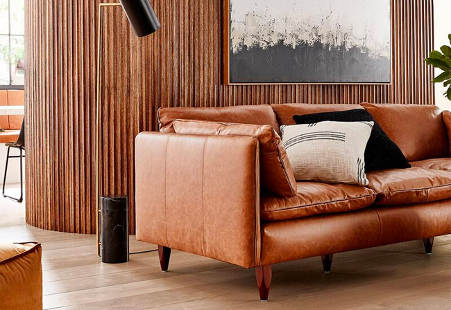 Freedom Eton leather sofa positioned under a piece of wall art. 