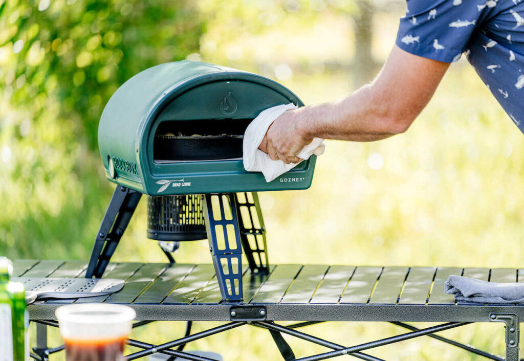 Person using a portable Gosney pizza oven.