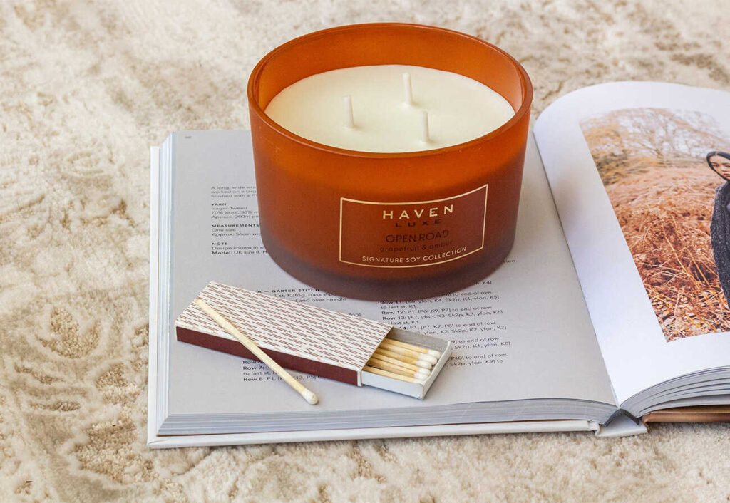 Haven Luxe Open Road Candle on an open book.