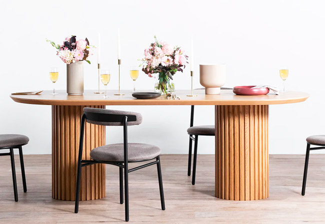Natural designer wooden dining table with padded chairs.