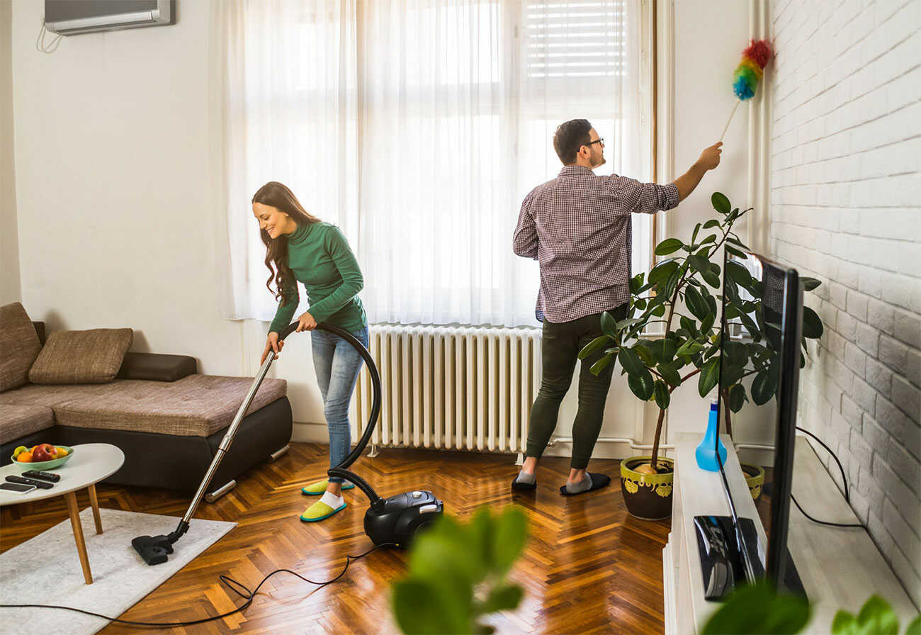 Couple cleaning a living room.