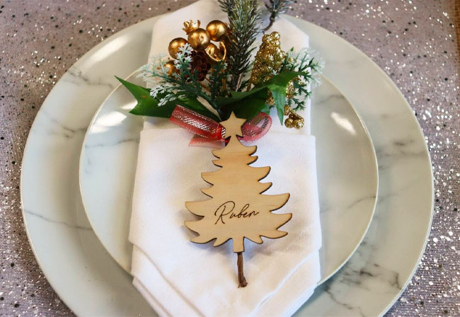 A personalised place card in the shape of a Christmas tree.