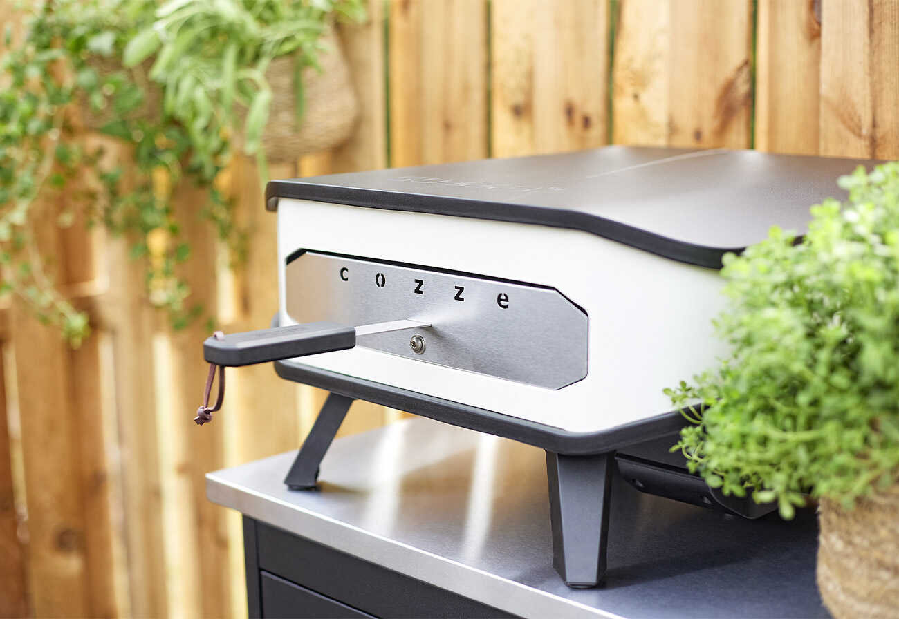 The Cozze Electrical Pizza Oven on an outdoor bench.