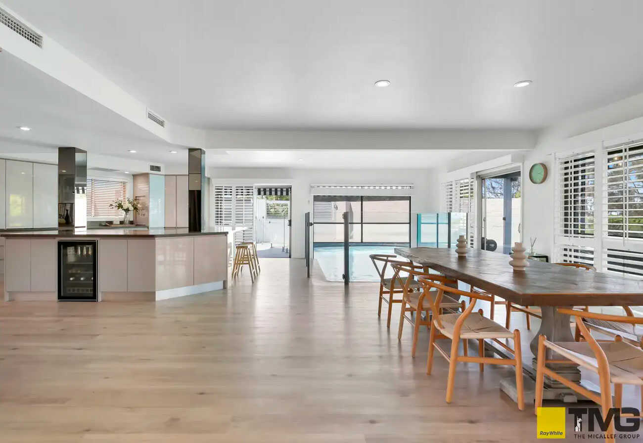 Open plan kitchen and dining area of a modern house with an indoor pool.