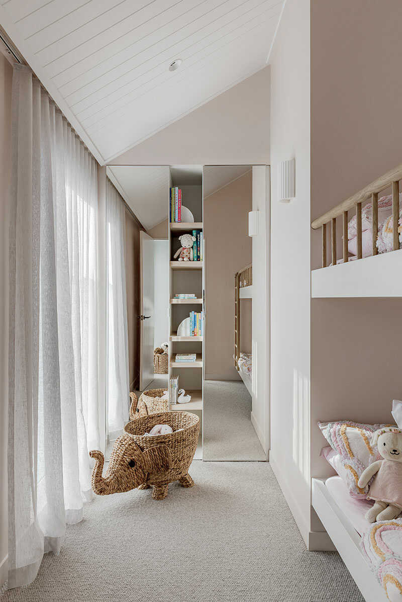 Kids bedroom in a neutral palette with mirrored wardrobes.