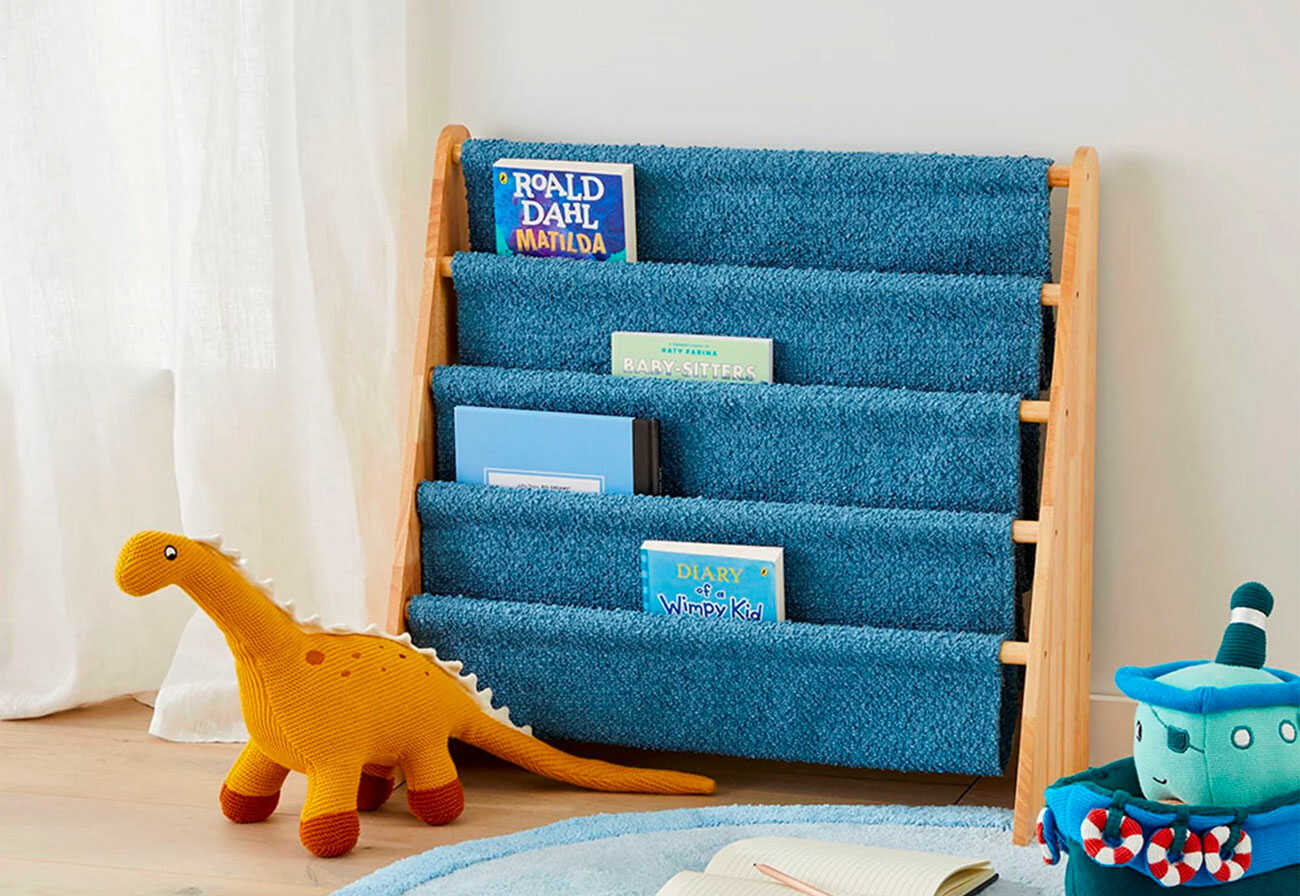 Blue bookshelf for kids with a toy dinosaur sitting in front of it.