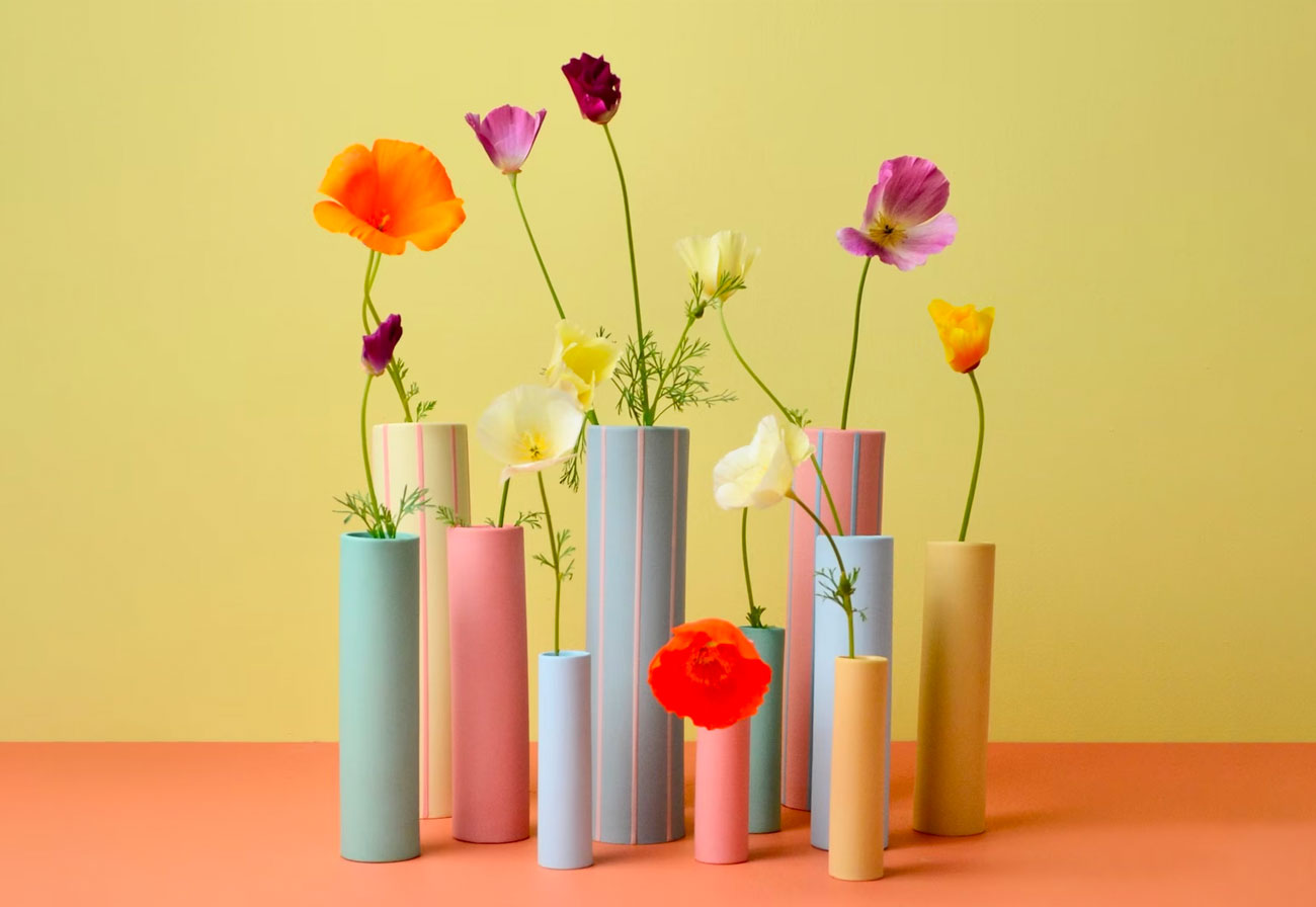 Coloured striped vases with a single flower in each.