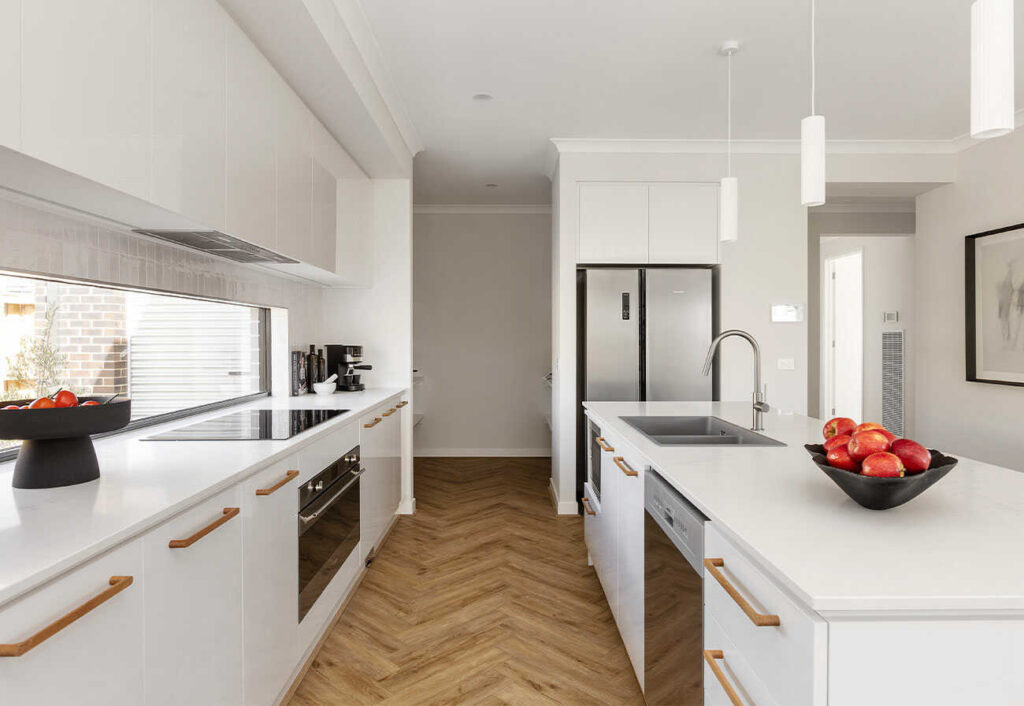 Galley style kitchen in a white palette with a butler's pantry at one end.