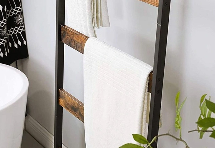 Towel draped over a decor ladder in a bathroom.
