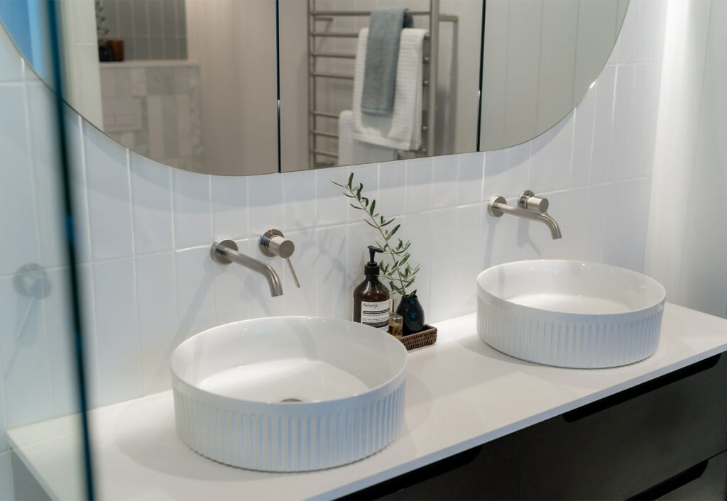 White basins with brushed nickel tapware.