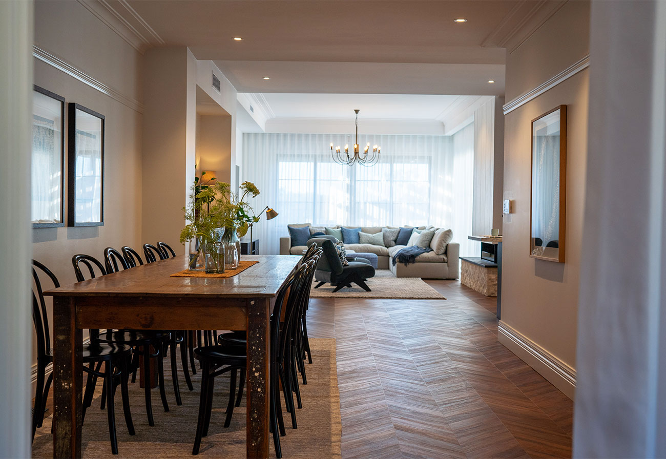View from dining area to living room with wooden herringbone floor.