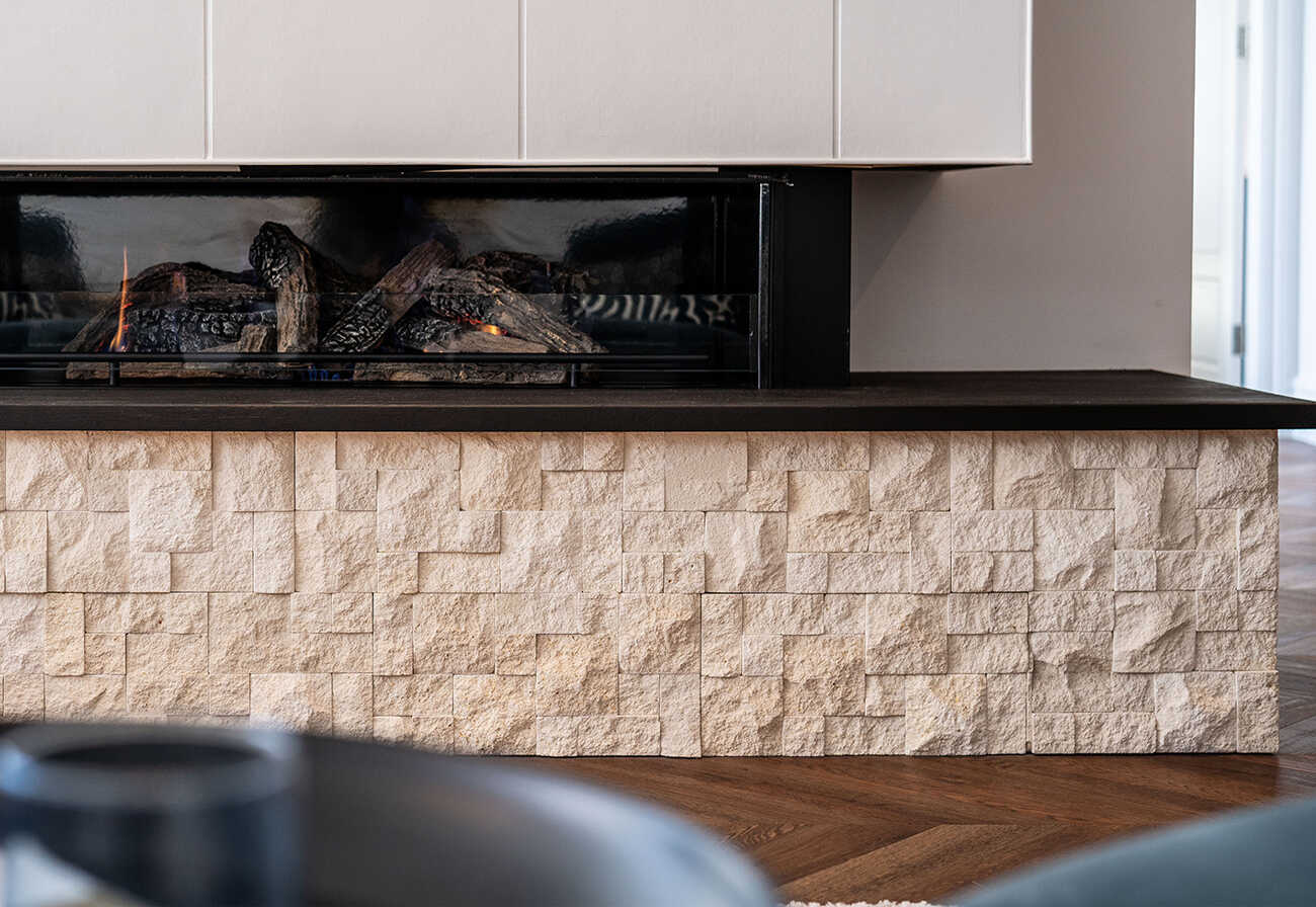 Built-in living room fireplace with limestone cladding base.