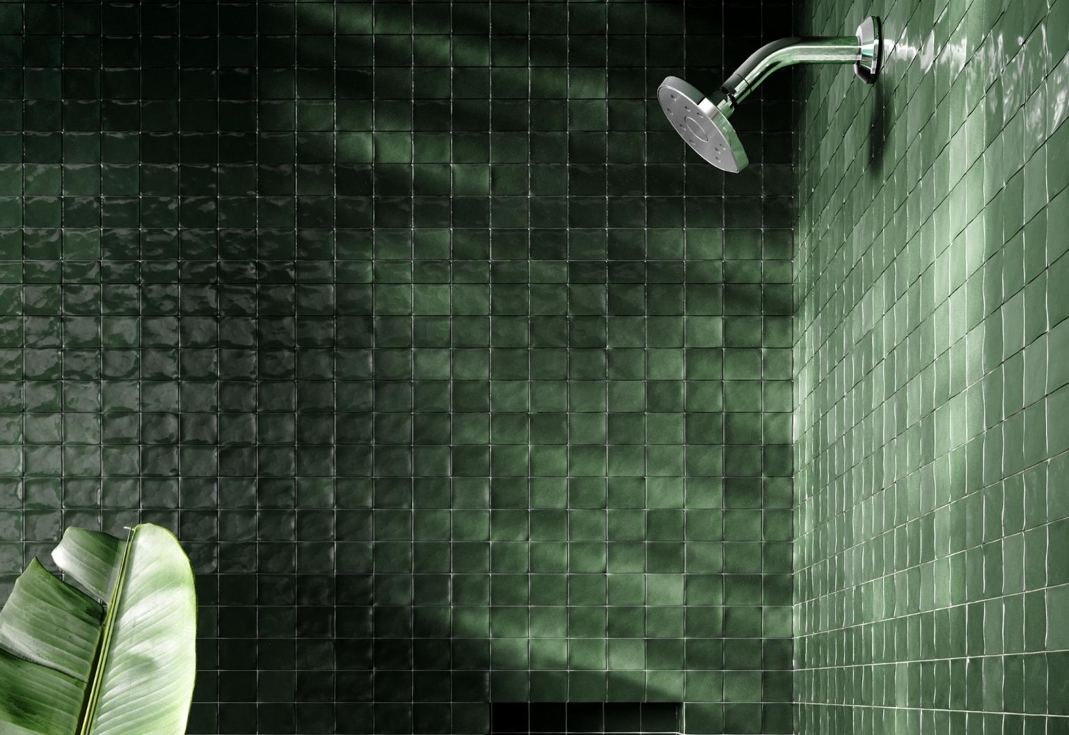 Methven shower head in a green tiled cubicle.